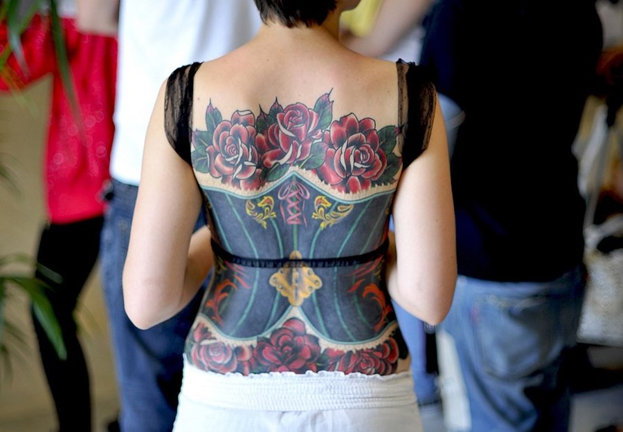 Красноволосая пышка в красном боди показала татуировку на спине