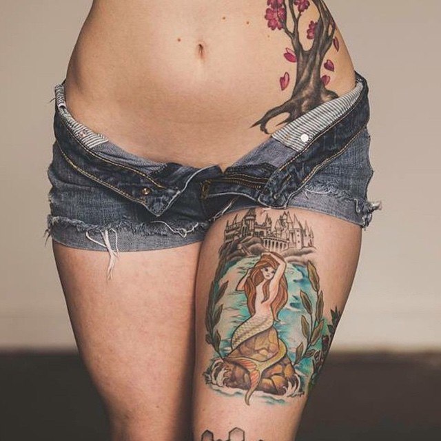 Сексуальная брюнетка в коротких шортах показывает тату на бедре и на груди